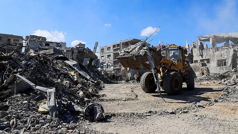 Heavy machinery removes debris from a street, amid a ceasefire between Israel and Hamas, in Gaza City, Oct 14, 2025. REUTERS