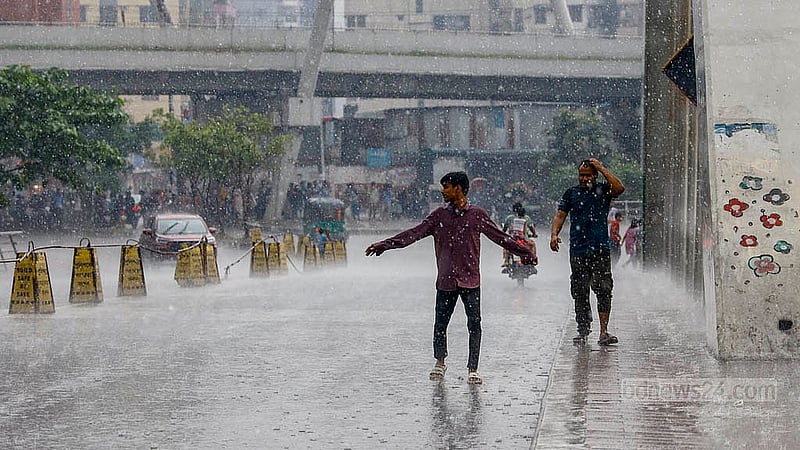 Two men enjoy the relief as darkened skies turn to rain in Dhaka’s Hatirjheel on Thursday, May 1, 2025. Photo: Mahmud Zaman Ovi