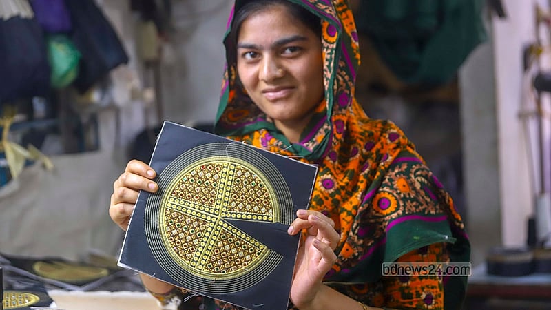 A female craftswoman shows a skull cap to a colleague at a factory in Dhaka’s Kamrangirchar. Photo: Abdullah al Momin