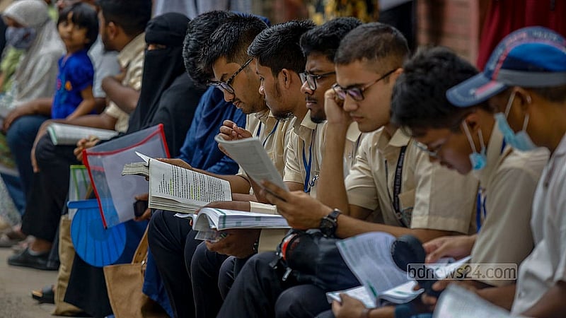 Just before the start of the exam, a student glances through a textbook outside the Siddeshwari Girls’ College centre. Photo: Mahmud Zaman Ovi