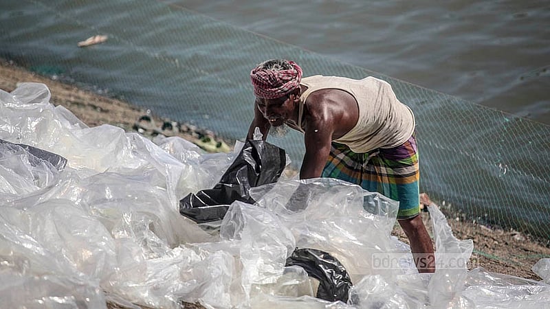 A worker washes polythene in the Buriganga River and spreads it out to dry along the bank in Dhaka’s Islambagh. Photo: Abdullah Al Momin