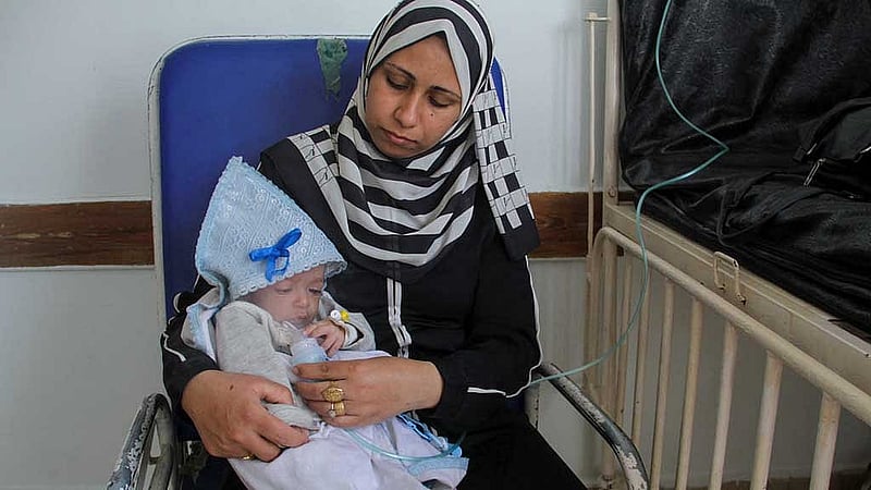 Palestinian woman Nisreen gives nebuliser treatment to her son Majd Salem, a six-month-old malnourished Palestinian baby who weighed 3.5 kg when he was born and gained just 300 grams in six months, at Kamal Adwan hospital in the northern Gaza Strip May 9, 2024. REUTERS