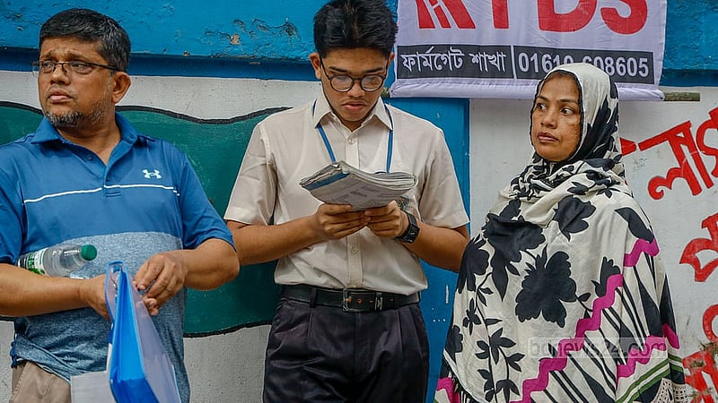 Just before the start of the exam, a student glances through a textbook outside the Siddeshwari Girls’ College centre. Photo: Mahmud Zaman Ovi