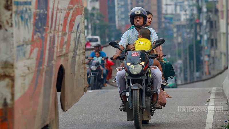 A child fell asleep on the front of a motorcycle on the busy Moghbazar-Mouchak flyover in Dhaka, yet the rider continued to ride. The rear passenger is not wearing a helmet. Photo: Mahmud Zaman Ovi