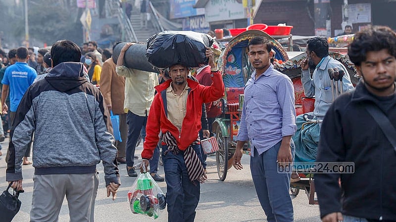 A man walks with a sack balanced on his head as he makes his way through the Science Laboratory intersection amid the student blockade on Thursday, Jan 15, 2026. Photo: Mahmud Zaman Ovi
