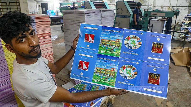 A worker checks the colours after printing the book covers at a printing house in the Matuail area of   Dhaka on Saturday, Nov 1, 2025. Photo: Abdullah al Momin