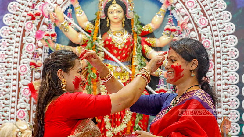 Hindu devotees smear vermillion on the idol of Goddess Durga and each other before bidding farewell to the goddess. Photo: Abdullah al Momin