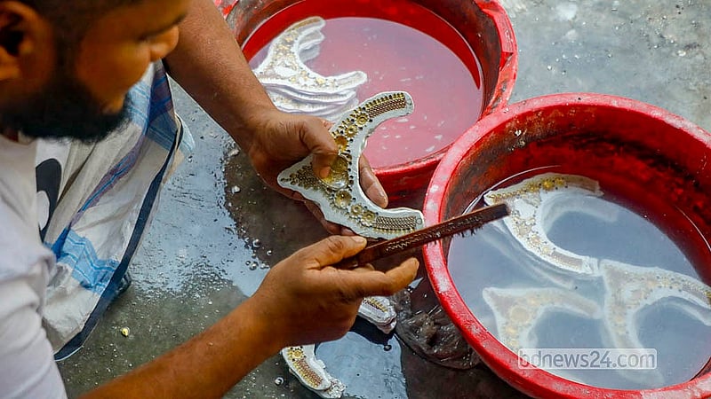 An artisan in Savar’s Bhakurta washes away the plaster used to hold jewellery in place during the soldering process. Photo: Abdullah Al Momin