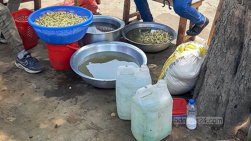 Potatoes prepared for shingara are washed with pond water at a stall inside Suhrawardy Udyan. Photo: Abdullah al Momin