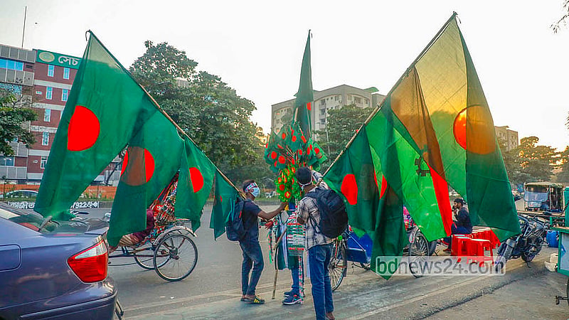 In the lead-up to Victory Day, the streets surrounding parliament are alive with vendors offering flags, badges, headbands, and other commemorative items. Photo: Abdullah Al Momin