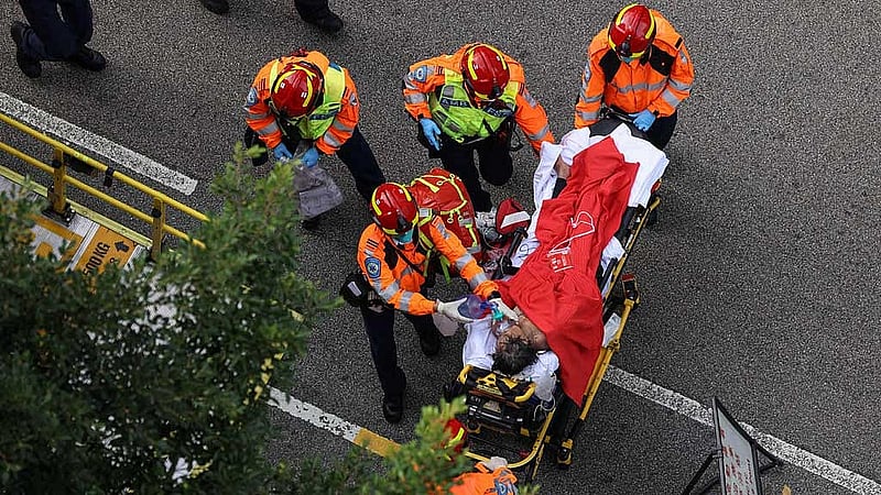 An injured resident is carried into an ambulance after a major fire engulfed bamboo scaffolding across multiple blocks at Wang Fuk Court housing estate, killing at least 55 people and leaving almost 300 missing, in Tai Po, Hong Kong, China, Nov 27, 2025. REUTERS/Tyrone Siu
