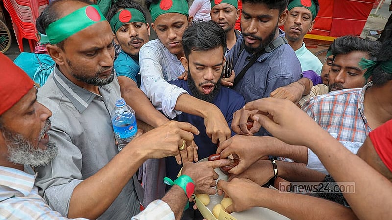 An organisation called July Revolution Army distributes sweets in Shahbagh on Monday, May 12, 2025, to celebrate the interim government’s decision to ban activities of the Awami League which was ousted in the July Uprising. Photo: Mahmud Zaman Ovi