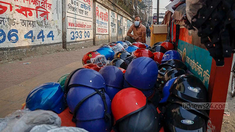 Bachchu Mia, a helmet vendor at the Science Lab intersection, says most of his customers are ride-share drivers who buy helmets primarily to avoid fines imposed by traffic police. Photo: Mahmud Zaman Ovi