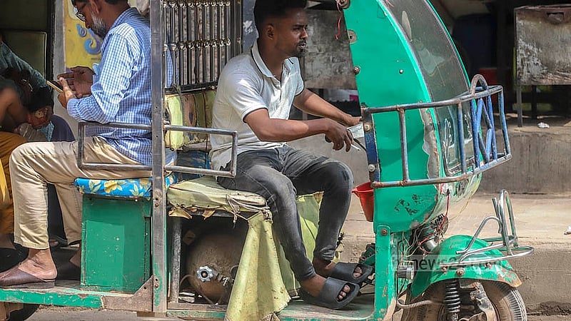 This autorickshaw has been put together using old gas cylinders and engines. A driver smokes while sitting on the risky, locally produced three-wheeler in Dhaka’s Basabo. Photo: Abdullah Al Momin