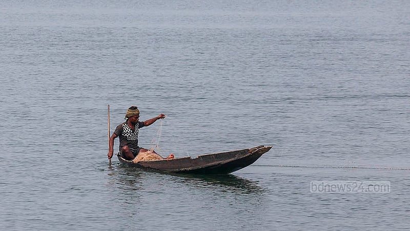 An individual sits in a dinghy while fishing in the clear waters of Tanguar Haor. Photo: Mahmud Zaman Ovi