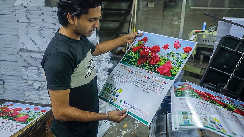 A worker checks whether the pages of a calendar have been printed correctly at a printing press in Dhaka’s Fakirapul. Photo: Abdullah Al Momin