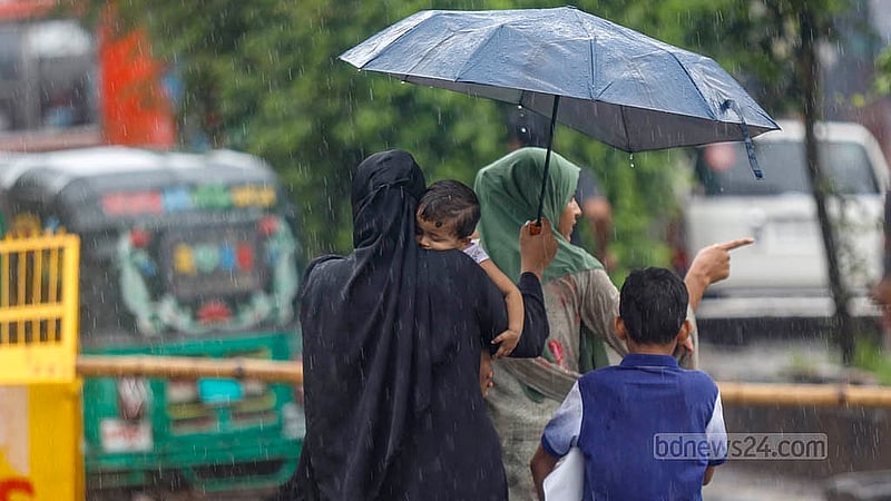 Amid heavy rain and the blockade by July Uprising victims at Dhaka’s Shahbagh, a woman carries her child in her arms while holding an umbrella. Photo: Mahmud Zaman Ovi