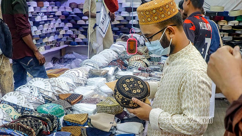 A customer browses skull caps at a shop outside the Baitul Mukarram Mosque ahead of Eid-ul-Fitr. Photo: Abdullah Al Momin