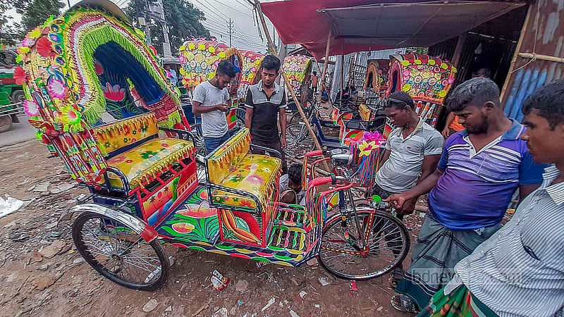 Customers browse battery-run rickshaws at a workshop in Dhaka’s Rayerbazar.
