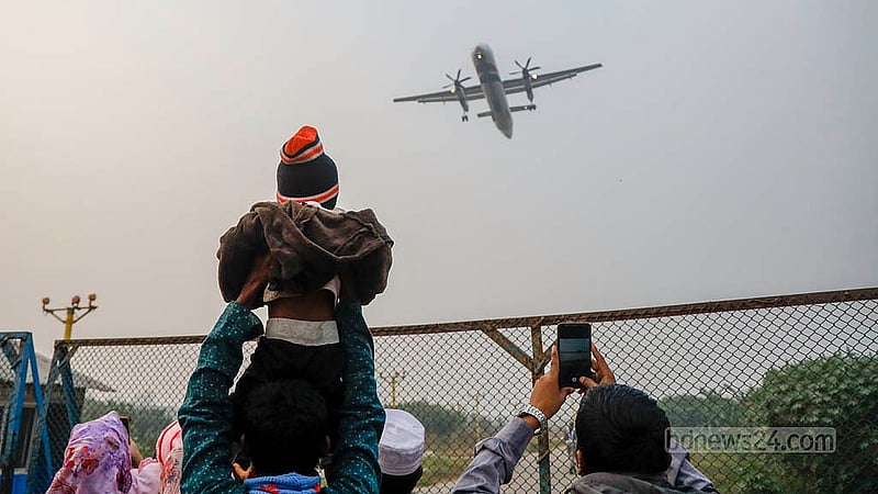 As an aircraft descends towards the runway at Dhaka's Hazrat Shahjalal International Airport, a father lifts his child onto his shoulders for a better view. Photo: Mahmud Zaman Ovi