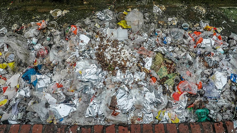 Discarded food packets, plastic bottles, and other waste from the stalls litter the pavement of Manik Mia Avenue, where they rot and release a stench across the area.Photo: Abdullah Al Momin
