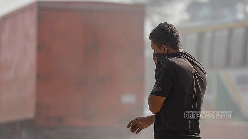 A man covers his face with his T-shirt to save himself from the dust on the Dhaka-Sylhet Highway in Narayanganj's Rupganj. Photo: Mahmud Zaman Ovi