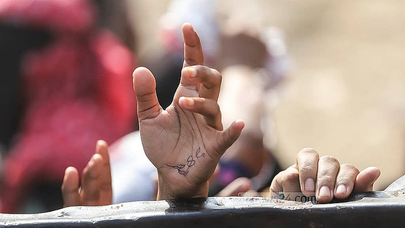 Those queuing to buy from the TCB trucks have serial numbers written on their hands. Though all the customers have serial numbers, many are eventually turned away when the stock runs out. Photo: Abdullah al Momin