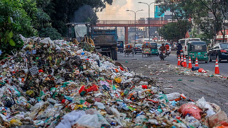 Garbage piles block one side of Pragati Sarani, forcing traffic through a single narrow lane. Photo: Mahmud Zaman Ovi