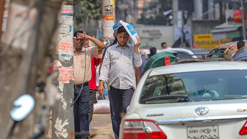 A man walks with a bag on his head to keep away the sunshine blazing down at Ittefaq intersection in Dhaka on Sunday, Apr 6, 2025. Photo: Abdullah al Momin