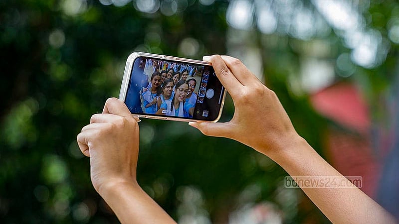 Students of Viqarunnisa Noon School and College capture the moment of SSC result celebrations on their mobile phone on Sunday, May 12, 2024.