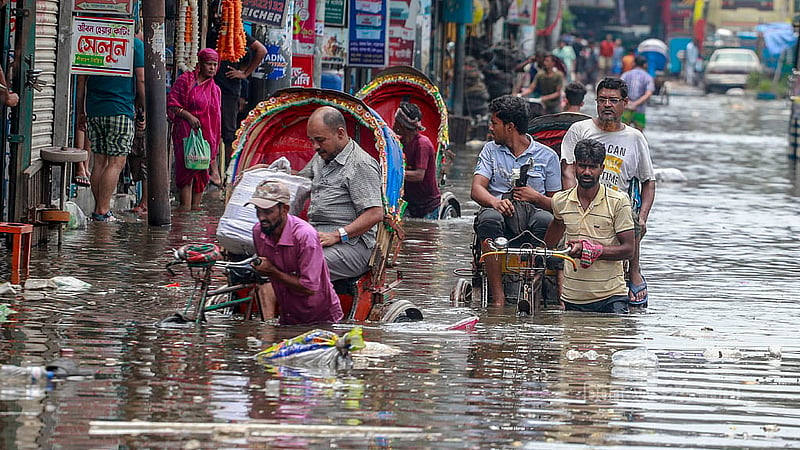 Local residents use rickshaws to traverse the waterlogged road next to the Syedabad Bus Stand in Dhaka on Tuesday, May 28, 2024 after a night of heavy rain brought on by Cyclone Remal. Photo: Muhammad Mostafigur Rahman