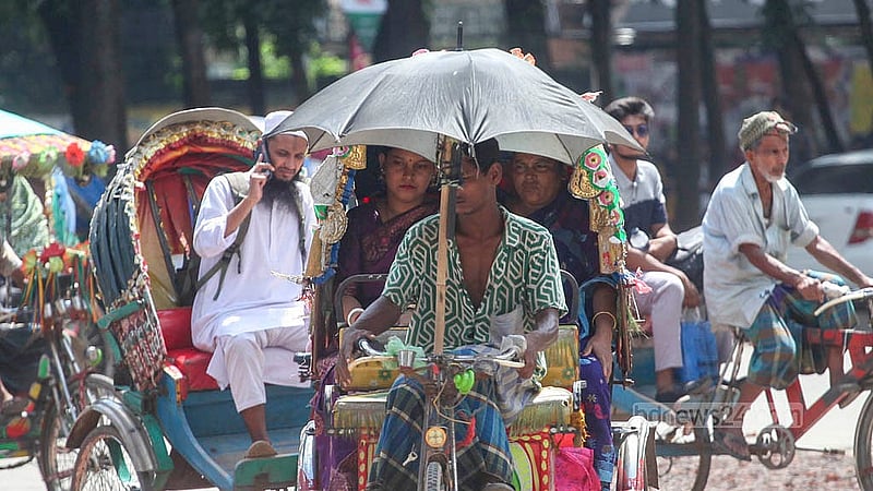 A rickshaw-puller affixes an umbrella to his vehicle for respite from the sun’s intensity. Photo taken near Dhaka University on Monday, Aug 11, 2025. Photo: Abdullah al Momin