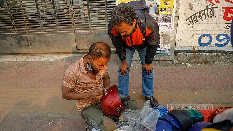 A temporary helmet shop run by Bachchu Mia on the footpath at the Science Lab intersection sells helmets and offers repairs for locks and visors. Photo: Mahmud Zaman Ovi