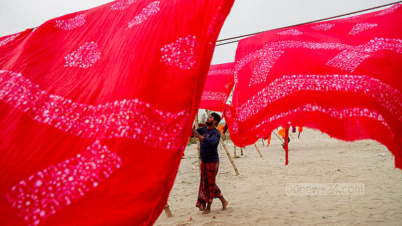 A worker dries freshly dyed batik fabric in an open area of Banti village in Narayanganj's Araihazar. Weak winter sunlight has made the drying process more difficult. Photo: Mahmud Zaman Ovi