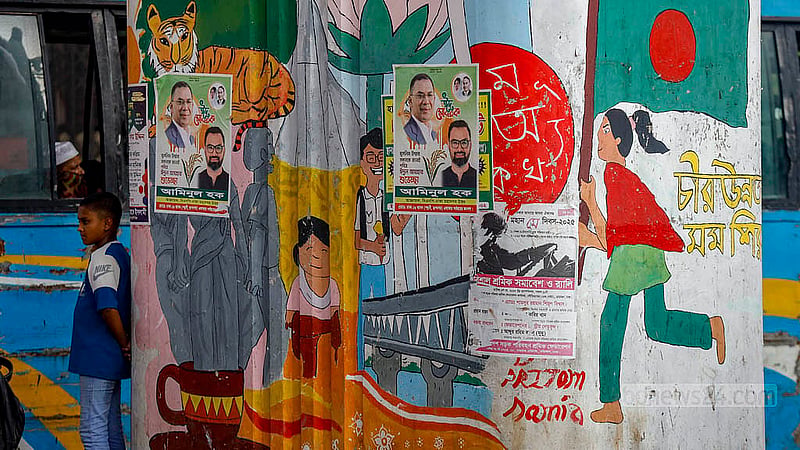 Graffiti commemorating the July Uprising once stood out on a pillar of the flyover at the Kalshi intersection in Dhaka. Now, within a year, they have been obscured b posters.. Photo: Mahmud Zaman Ovi