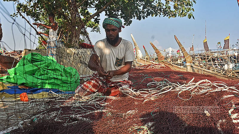 Fishermen repair nets in Chattogram’s Fisheryghat area during a ban on marine fishing. Photo: Suman Babu