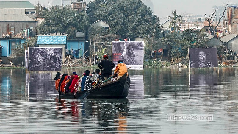 Local residents pass by the floating exhibition on boats at Korail Lake. The exhibition has been organised by photographer Parvez Ahmed Rony to mark Felani Day and protest border killings. Photo: Abdullah Al Momin