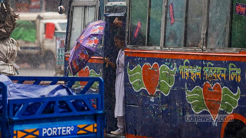 A student carrying an umbrella gets down from a bus during heavy rain at Mohammadpur bus stand in Dhaka on Monday, Jul 1, 2024. Photo: Mahmud Zaman Ovi