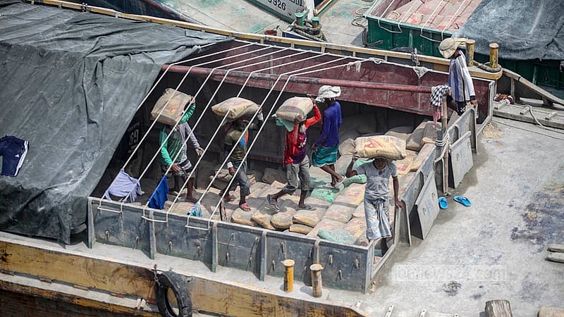Workers unload cement from barges under Dhaleshwari Bridge No. 1 in Keraniganj. Photo: Abdullah Al Momin