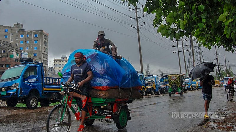 Pedestrians in Mohammadpur face difficulties due to the persistent rain brought on by Cyclone Remal on Monday, May 27, 2024.