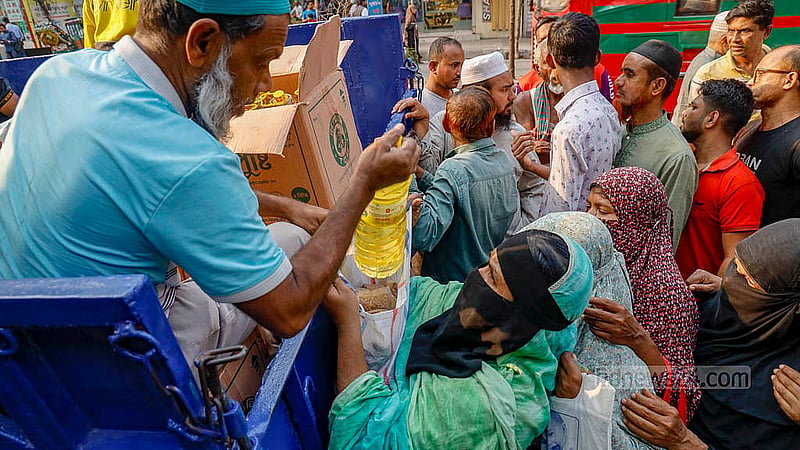 A woman collects goods from a Trading Corporation of Bangladesh (TCB) truck under the scorching heat on Wednesday, Feb 18, 2026, near the Town Hall in Dhaka’s Mohammadpur. Photo: Mahmud Zaman Ovi