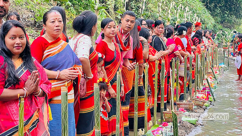 On the morning of Hari Boisu, the last day of Chaitra, Tripura women and children gather with flowers on the banks of Khagrachhari's Chengi River. Photo: Samir Mallik