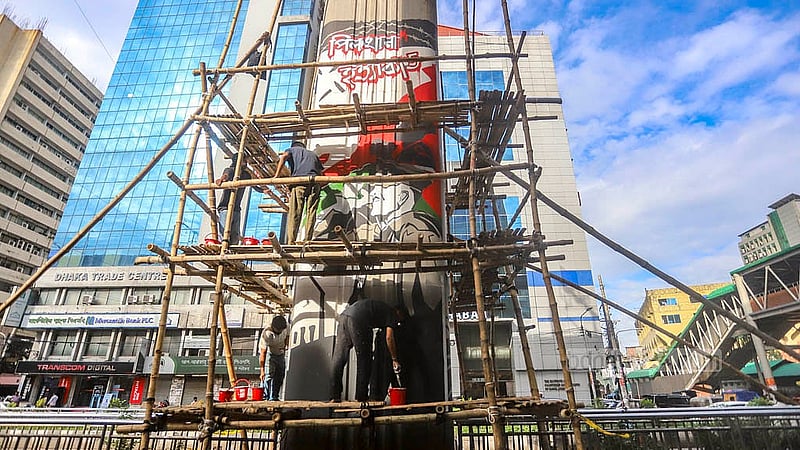 Artists, including students from different educational institutions, paint graffiti portraying the activities under the ousted Awami League government on the pillars of Dhaka’s Karwan Bazar metro rail station on Saturday, Jul 5, 2025. Photo: Abdullah al Momin