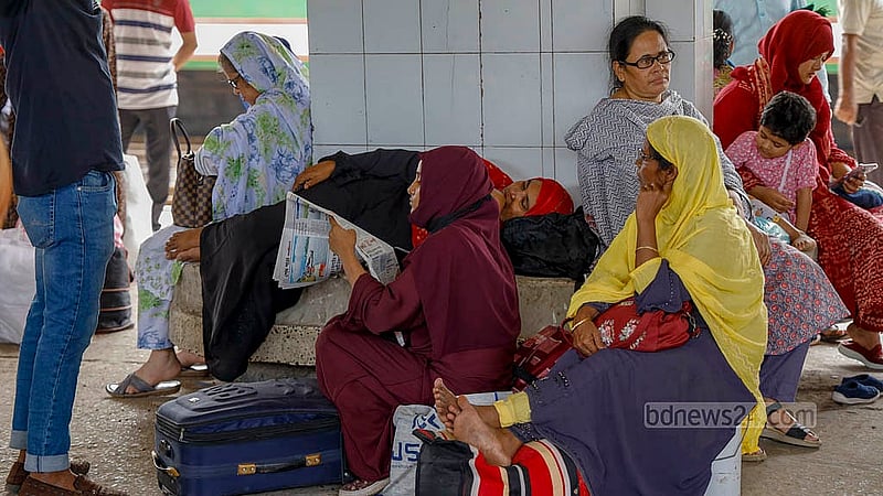 Due to the train accident, passengers at Kamalapur Station spent the day navigating the schedule chaos on Friday, October 25, 2024; some passengers are reading newspapers, while others are occupied with their mobile phones. Photo: Mahmud Zaman Ovi