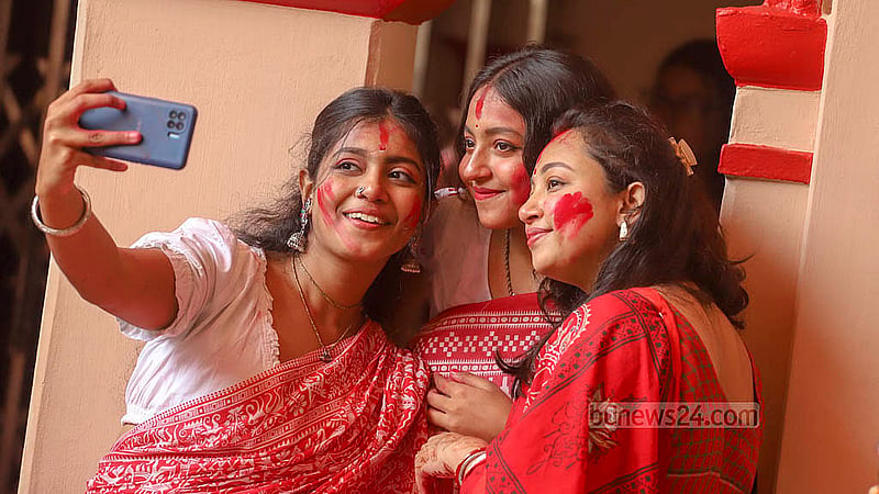 People take pictures while partaking in ‘Sindur Khela’ before the immersion of the idol of Goddess Durga at Dhakeshwari Temple on Sunday, Oct 13, 2024. Photo: Abdullah al Momin