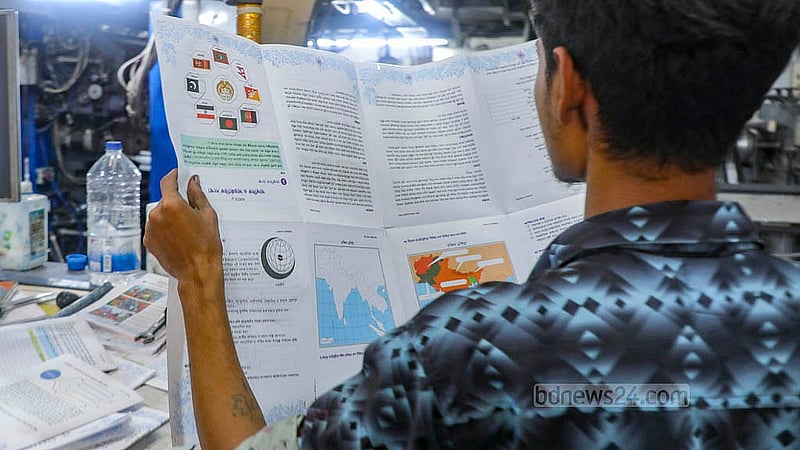 A worker at a printing house in Matuail checks freshly printed textbooks to ensure they are in order on Saturday, Nov 1, 2025. Photo: Abdullah al Momin