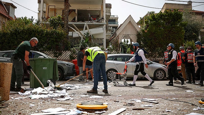 People clean debries at an impact site, following a barrage of missiles launched from Iran, amid the U.S.-Israeli conflict with Iran, in Ramat Gan, Israel, April 4, 2026. Photo: Reuters