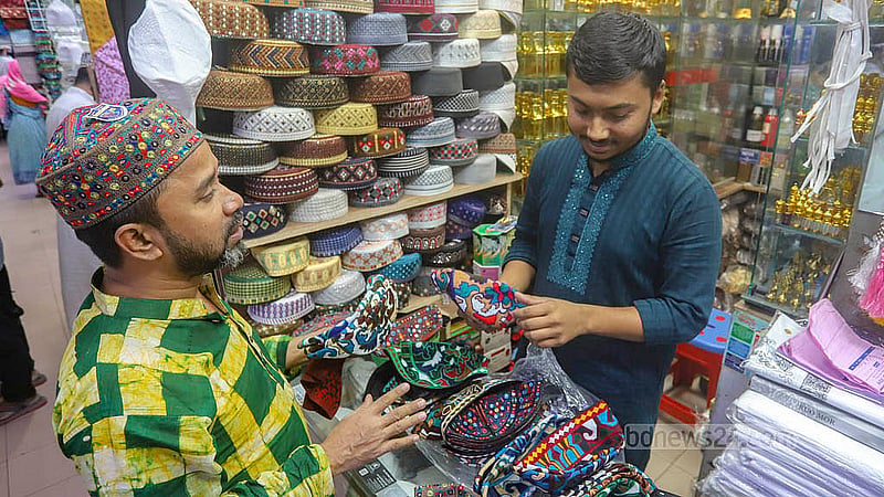 A crowd of shoppers gather at a skull cap shop in front of the Baitul Mukarram Mosque ahead of Eid ul-Fitr. Photo: Abdullah al Momin