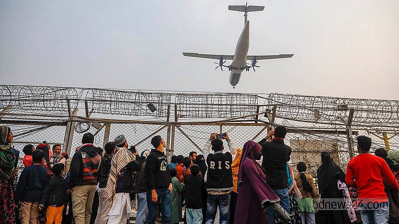 Crowds wait along the barbed-wire fence near the runway at Dhaka's Hazrat Shahjalal International Airport, hoping to catch a close-up view of the planes. Photo: Mahmud Zaman Ovi