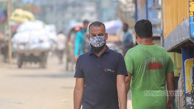 Due to extreme dust pollution, people traversing the Beribadh Road in the capital are often forced to wear masks for protection. Photo: Abdullah al Momin